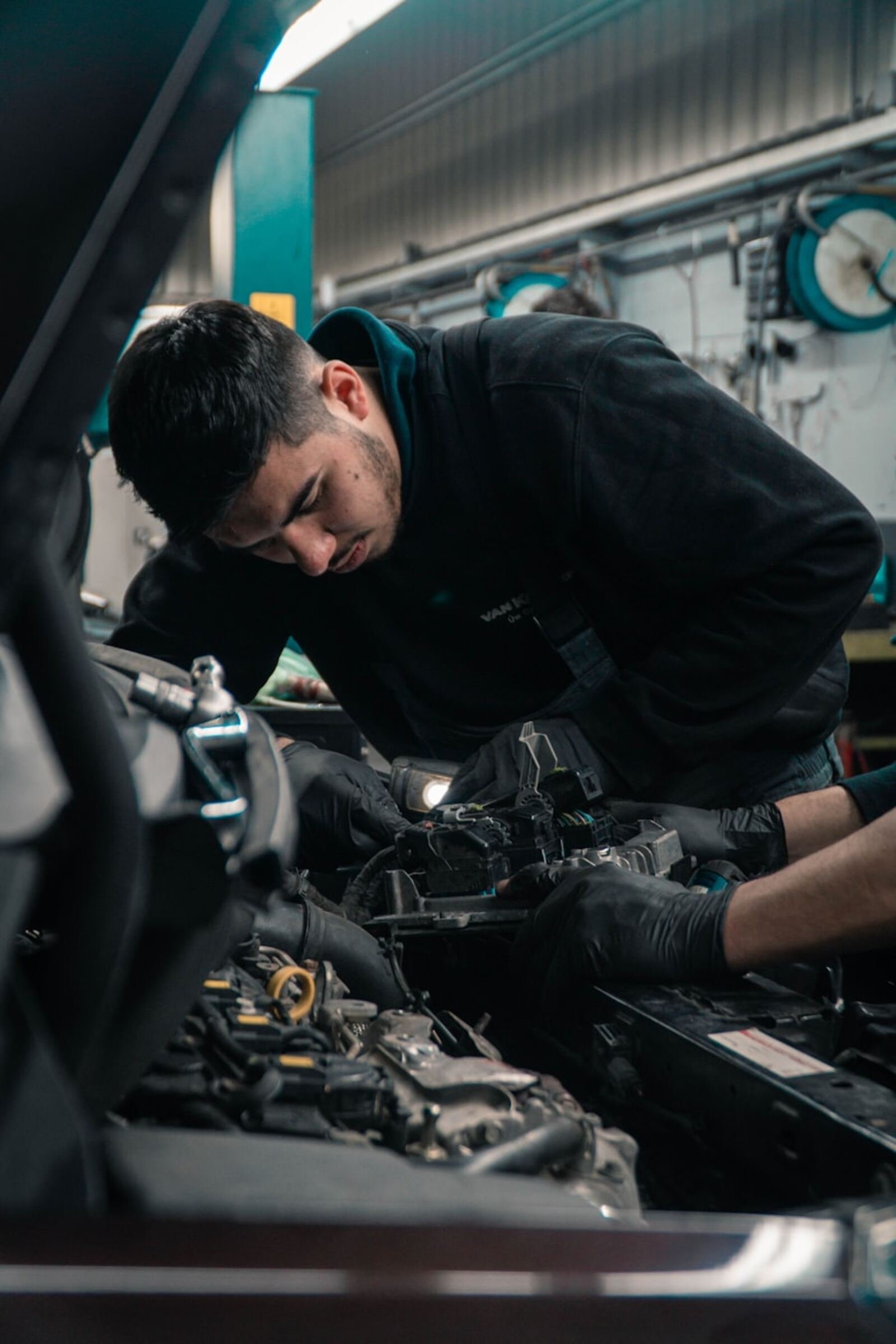 Technicien concentré travaillant sur le moteur d'un véhicule